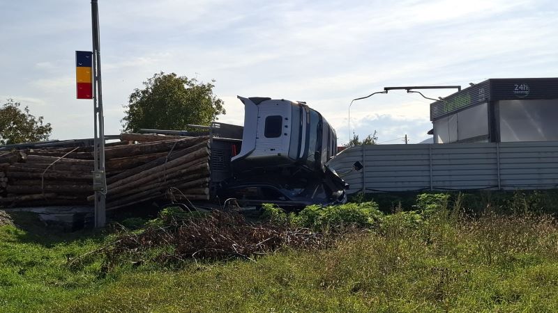 Un TIR încărcat cu lemne s-a răsturnat peste un autoturism 